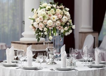 Formal wedding reception complete with floral arrangement and folded napkins