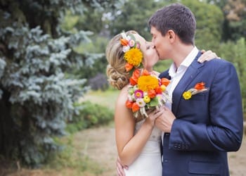 A bride and groom kissing at their outdoor wedding