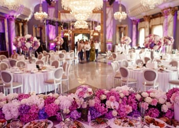 Purple floral arrangements and lighting at a wedding reception
