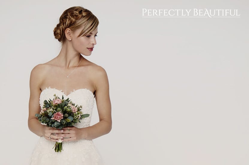 A beautiful bride in an off-the-shoulder dress holding a simple bridal bouquet