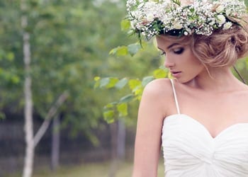 A bride who has added makeup to her face shoulders and neck