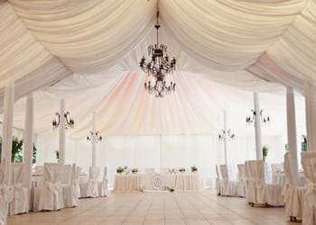 Perfectly Beautiful Over The Top Wedding View of a main ballroom area underneath a large wedding tent